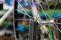 Bicycle repair. The front wheel is on a stand on the background of the board with tools. Rim and spokes close-up. Mechanic levels Royalty Free Stock Photo