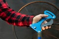 Bicycle repair. In the mechanic's hand is a professional tool for repairing wheels and tensioning spokes.