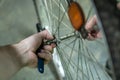 Bicycle repair. Old rusty wheel. The mechanic in the workshop, in his hand holds a wrench. On the spokes hanging cobwebs and dust Royalty Free Stock Photo