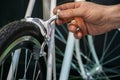 Bicycle repair. Restoration of a very old road racing bike. Rear V-brake and tire closeup. White frame. The mechanic adjusts rear