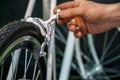 Bicycle repair. Restoration of a very old road racing bike. Rear V-brake and tire closeup. White frame. The mechanic adjusts rear Royalty Free Stock Photo