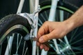 Bicycle repair. Restoration of a very old road racing bike. Rear V-brake and tire closeup. White frame. The mechanic adjusts rear