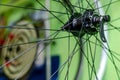 Bicycle repair workshop. On the hook hang new wheels. The rim, spokes and hub black colour. The old bike here is gets a second