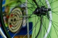 Bicycle repair workshop. On the hook hang new wheels. The rim, spokes and hub black colour. The old bike here is gets a second