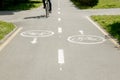 Bicycle ride on urban lane, shadow of unrecognizable cyclist riding a bike through city street next to the road marking. Healthy Royalty Free Stock Photo