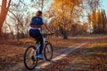 Bicycle ride workout in autumn park. Young woman biker riding a bike in fall forest. Healthy training Royalty Free Stock Photo