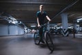 Bicycle rider rides on an underground parking lot. cyclist rides in an underground parking lot Royalty Free Stock Photo