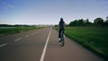 Unknown bicycle riders move along the park bike path Royalty Free Stock Photo