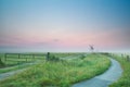Bicycle road to windmill in sunrise fog Royalty Free Stock Photo