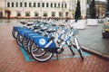 Bicycle-sharing system. Many blue shared bikes on street parking. Bicycle rental service spot on city street. Public