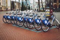 Bicycle-sharing system. Many blue shared bikes on street parking. Bicycle rental service spot on city street. Public