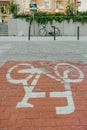 Bicycle sign on the stone ground with a parked rental bike in the distance in the Lazarz district