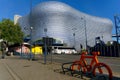 Bicycle stand and bus in front of a modernist shopping mall