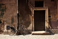 Bicycle standing next to an old wall and door