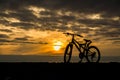 Silhouette of a bicycle against the setting sun.