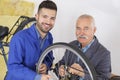 Bicycle trainee mechanic and master working on mountain bike Royalty Free Stock Photo