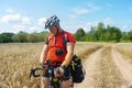A Bicycle traveller in a field, a cyclist looking for a road