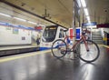 A bicycle waiting for a train in a Madrid Metro station.