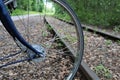 Parallel train tracks next to rail trail seen through spokes of bicycle wheel