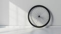 Bicycle wheel leaning against a white wall in a room with sunlight casting a shadow Royalty Free Stock Photo