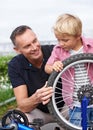 Bicycle, wheel or repair with father and son outdoor in neighborhood for learning or child development. Family, street Royalty Free Stock Photo