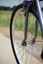 Bicycle wheel with road and greenery in the background.