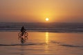 Cyclist riding to sunset on Cox Bay Beach Royalty Free Stock Photo