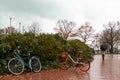 Bicycles in autumn park without people on rainy day on background of girl with umbrella