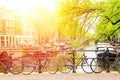 Bicycles on the bridge in Amsterdam, Netherlands against a canal with a sunlight. Amsterdam postcard. Tourism concept.