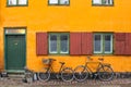 Bicycles in front of an yellow orange house facade in Nyboder,historic row house district of former Naval barracks in Copenhagen, Royalty Free Stock Photo