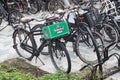 Bicycles locked on bicycle stands in the street. Heineken box on front rack