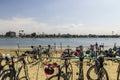 Bicycles parked on metal bike racks in the sand at Horny Corner Beach with blue ocean water and luxury homes, boats and yachts