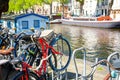 Bicycles parking lot in Amsterdam, Netherlands against a canal during summer sunny day. Amsterdam postcard iconic view. Tourism Royalty Free Stock Photo