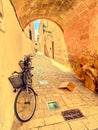 bicycles propped against wall in sunny and vibrant street in ciutadella menorca spanish balearic islands Royalty Free Stock Photo