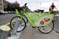 Bicycles on a public bike-sharing systems docking station. A man is cycling on the background. Royalty Free Stock Photo