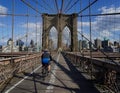 Bicyclist crossing empty Brooklyn Bridge during the coronavirus COVID-19 pandemic lockdown in New York City Royalty Free Stock Photo