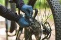 Bicyclist hands reparing bike chain in the middle of forest