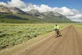 Bicyclist riding through spring flowers and mountains in Centennial Valley near Lakeview, MT