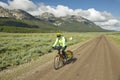 Bicyclist riding through spring flowers and mountains in Centennial Valley near Lakeview, MT