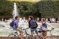 Bicyclists chat in front of fountain in Palais Royal garden in P Royalty Free Stock Photo