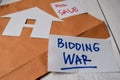 Bidding War and House For Sale write on sticky notes isolated on Office Desk Royalty Free Stock Photo