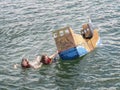 BIDEFORD, DEVON - JUNE 11 2023: Entrant craft sinking in the annual Cardboat Boat Race on the River Torridge.