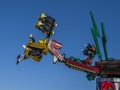 BIDEFORD, NORTH DEVON ENGLAND - MARCH 19 2022. Funfair ride, people upside down in the air. Blue sky.