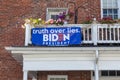 A Biden for President banner on the second floor balcony of an old house