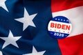 biden presidential election campaign 2020 vote button; pin laying on the american flag.