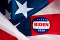 Biden presidential election campaign 2020 vote button, pin laying on the american flag.