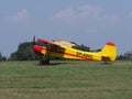 Side of sport Yakovlev Yak-12M SP-AWG airplane lands on green grassy airfield in european Bielsko-Biala city, Poland