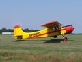 Side of yellow Yakovlev Yak-12M SP-AWG airplane lands on green grassy airfield in european Bielsko-Biala city, Poland