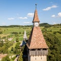 Biertan town and Biertan lutheran evangelical fortified church spires and clock tower. Transylvania, Romania. Aerial close view.