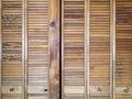 Bifold louvered closet doors with knotty woodgrain texture Royalty Free Stock Photo
